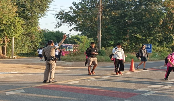 ร.ต.อ.คมศักดิ์ สารบรรณ รอง สวป.สภ.ห้วยคต อำนวยความสะดวกจัดการจราจรเพื่อป้องกันอุบัติเหตุ บริเวณด้านหน้าทางเข้าโรงเรียน